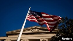 Bendera Amerika melambai di luar Gedung Departemen Kehakiman AS di Washington, AS, 15 Desember 2020. (Foto: Reuters)