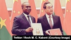 Le ministre burkinabè Alpha Barry, à gauche, et son homologue chinois des Affaires étrangères Wang Yi ont signé un communiqué conjoint annonçant l’établissement des relations diplomatiques entre le Burkina Faso et la Chine, à Pékin, 26 mai 2018. (Twitter/ Roch M. C.