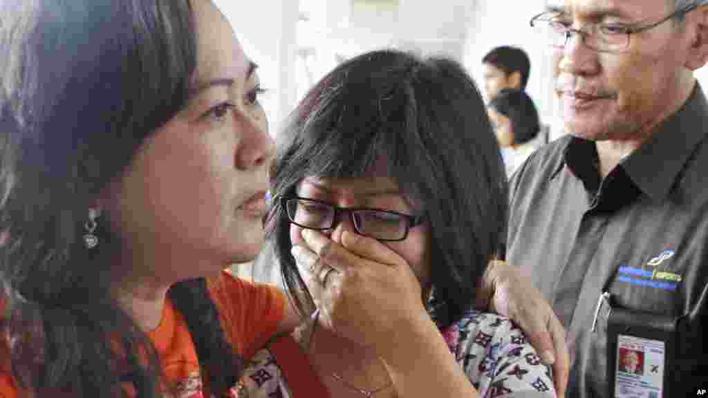 Un parent d'un passagers du vol d'AirAsie 8501pleure alors qu'elle attend les dernières nouvelles sur l'avion de ligne à l'aéroport international Juanda à Surabaya, Est Java, en Indonésie, le 28 décembre 2014.