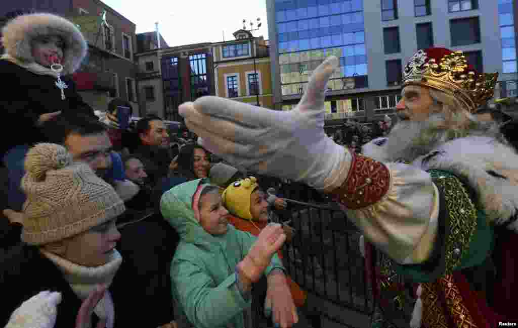 Un hombre disfrazado como uno de los Tres Reyes Magos saluda a los niños que asistieron al desfile de la Epifanía en Gijón, al norte de España, el cinco de enero del 2019. 