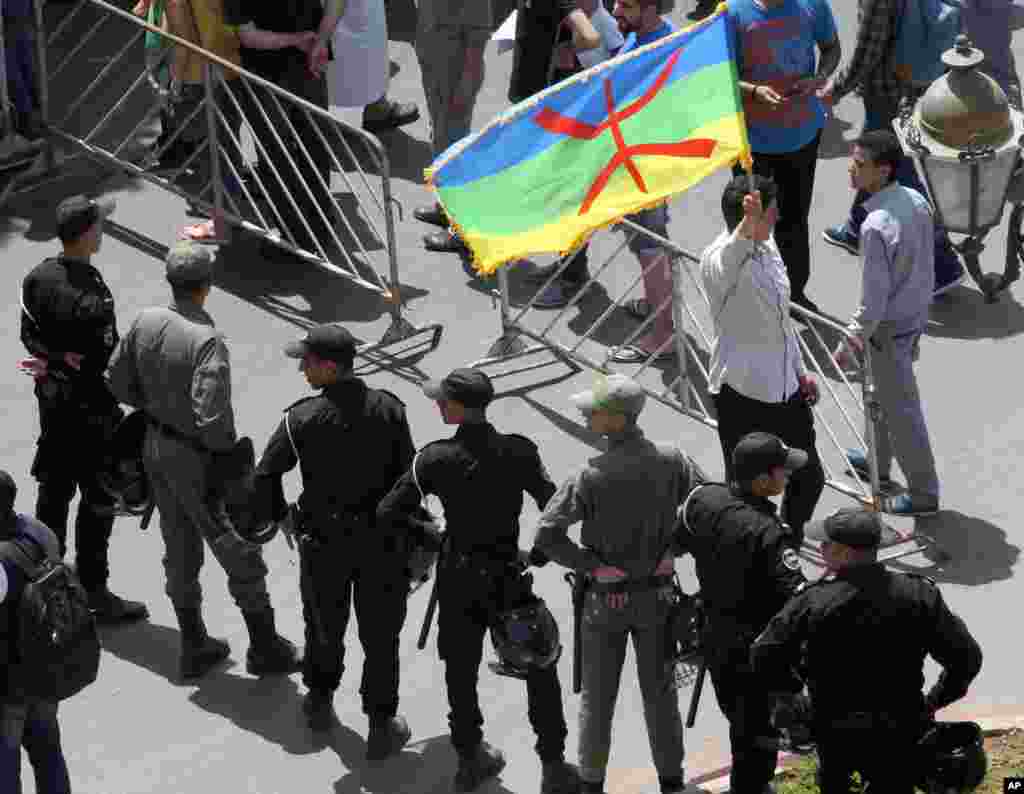 Wani na dauke da tutar Abzinawa a gaban wasu 'yansanda a lokacin wata zanga zanga ta nuna rashin amincewarsu da gwamnatin akan saboda yawan cin hanci da rashawa, ranar Lahadi 11 ga watan Yuni shekarar 2017. 