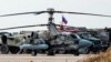 ARCHIVO - Un helicóptero de ataque militar Kamov Ka-52 Alligator de la Fuerza Aérea rusa es fotografiado junto a otros camiones y vehículos en la base aérea rusa del aeropuerto de Qamishli, en el noreste de Siria, el 12 de diciembre de 2024. AFP