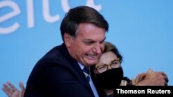 El presidente de Brasil, Jair Bolsonaro, saluda a la ministra de Agricultura, Tereza Cristina, durante la ceremonia de lanzamiento del Plano Safra 2020/2021, un plan de acción para el sector agrícola, en Brasilia. Foto Archivo.