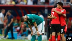 Germany's Niklas Suele, left, is dejected as South Korea's Son Heung-min, right, celebrates after the group F match between South Korea and Germany, at the 2018 soccer World Cup in the Kazan Arena in Kazan, Russia, Wednesday, June 27, 2018. (AP Photo/Frank Augstein)