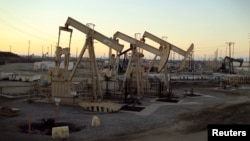 FILE - Oil rig pumpjacks, also known as thirsty birds, owned by Occidental Petroleum Corporation, operate near Long Beach, Calif., July 30, 2013.