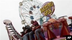 Dua pengunjung Coney Island sedang menaiki wahana "Electro Spin" di Luna Park (foto: Dok).