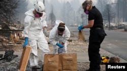 Forensic anthropologists Kyra Stull and Tatiana Vlemincq work with San Mateo County Deputy Coroner Elizabeth Ortiz to recover human remains from a trailer home destroyed by the Camp Fire in Paradise, California, U.S., November 17, 2018.