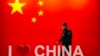 安保人员从中国国旗和“我爱中国”标志旁走过。