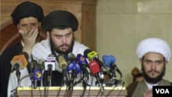 Ulama Syiah Moqtada al-Sadr (tengah) menyerukan "perlawanan militer" terhadap pelatih militer AS yang tetap berada di Irak setelah akhir tahun ini.