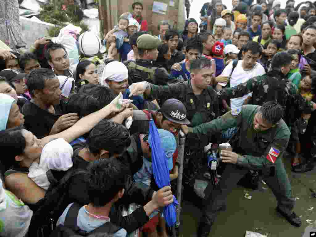Typhoon survivors jostle to get a chance to board a C-130 military transport plane in Tacloban, Nov. 12, 2013.