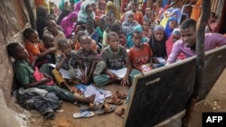 L'étudiant universitaire Yahye Mohamed donne une leçon aux enfants déplacés en tant que professeur bénévole dans une école de fortune au camp de Badbado à Mogadiscio, en Somalie, le 25 juin 2018.