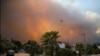 A helicopter flies as a fire engulfs the area in Oren, near Bodrum, Turkey, Aug. 3, 2021.