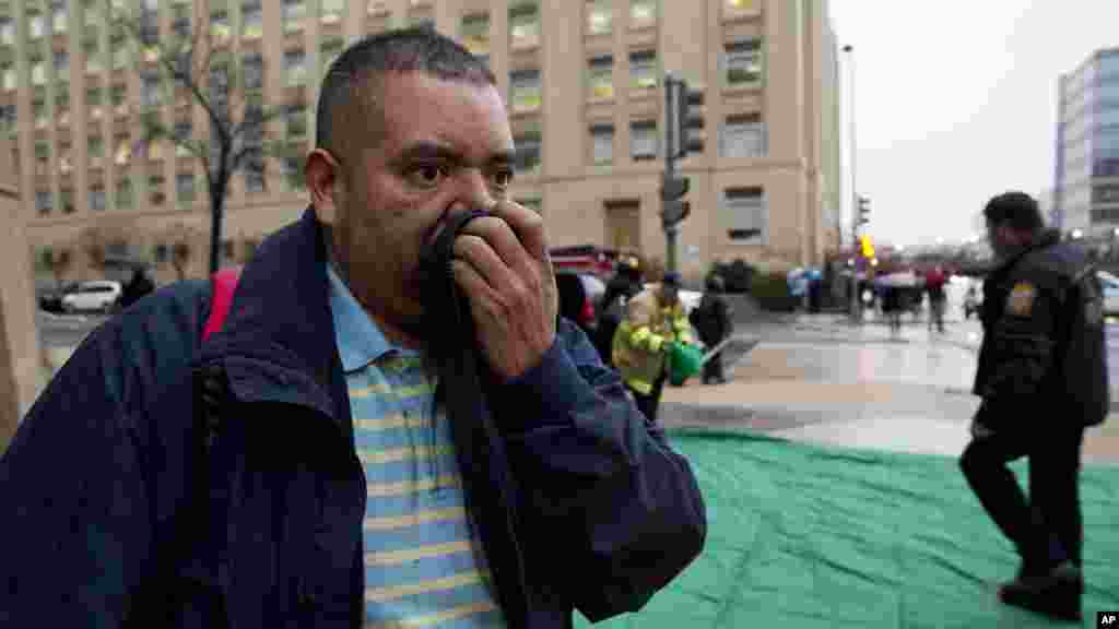 Reynaldo Hernandez se couvre le nez pendant qu'il tousse interminablement après avoir été évacués d'un tunnel enfumé de métro à Washington, lundi 12 janvier, 2015.