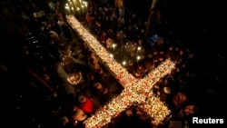 Vernici se okupljaju oko sveća u teglicama, tokom liturgije ispred pravoslavne crkve u Bugarskoj, 10 februara 2016.