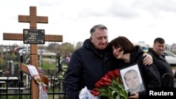 People mourn at the cemetery in Bucha