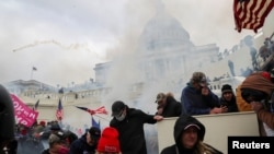 Pristalice predsednika Donalda Trampa tuku se sa policajcima ispred zgrade Kapitola u Vašingtonu, 6. januara 2021. 
