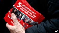 A Pro-Brexit campaigner hands out leaflets at Liverpool Street station in London, Wednesday, March 23, 2016. With less than three months to go until a June 23 referendum, Britain's anti-EU campaigners are bitterly divided, with two rival camps battling over which will be the standard-bearer in the campaign, and over how to win the historic vote. (AP Photo/Frank Augstein)