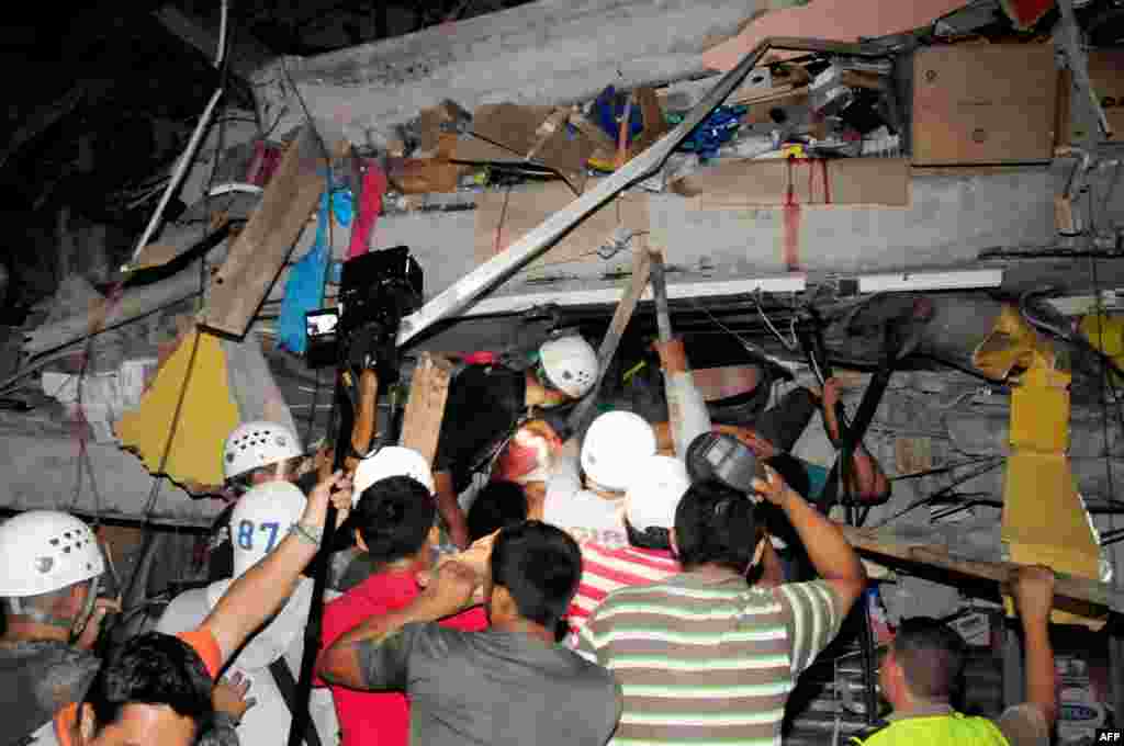 Rescue workers work to pull out survivors trapped in a collapsed building after a huge earthquake struck, in the city of Manta, April 17, 2016.