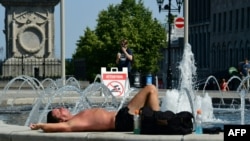 Un hombre toma el sol cerca de una fuente de agua en el casco antiguo de Montreal, Canadá, el 2 de julio de 2018.