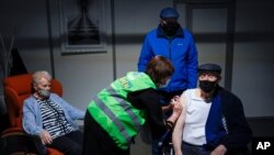 Seorang pria disuntik dosis pertama vaksin COVID-19 buatan AstraZeneca dalam vaksinasi massal di Heverlee, Belgia, 17 Maret 2021. 