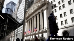 FILE PHOTO: People are seen on Wall St. outside the NYSE in New York