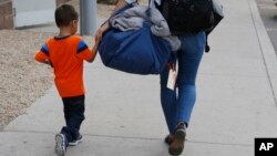 José, de tres años, originario de Honduras, es ayudado por una representante de Southern Poverty Law Center para que se reúna con su padre el martes, 10 de julio de 2018, en Phoenix, Arizona.