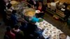 Breakfast of rice, beans and tortilla chips is prepared for Honduran migrants inside an empty warehouse that opened its doors to migrants in downtown Tijuana, Mexico, Dec. 18, 2018. The owner opened the warehouse, closed for years, so some migrants don't sleep outside.
