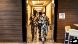 资料照片：几内亚军政府士兵在军政府与西非经济共同体代表举行会议的科纳克里的一家酒店内巡逻（2021年9月17号）。