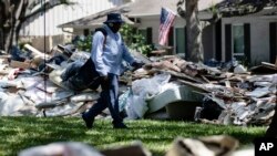 Petugas kantor pos, Lonzell Rector, sedang bertugas mengantar surat, melewati rongsokan rumah-rumah yang dirusak banjir setelah Badai Harvey di Houston, 7 September 2017. 