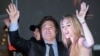 El presidente electo de Argentina, Javier Milei, y su pareja Fátima Flores, saludan a sus partidarios en su sede de campaña después de ganar el balotaje, el 19 de noviembre de 2023.