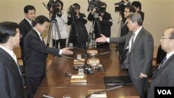 Ketua Delegasi Korsel Ryu In-chang (kanan) berjabat tangan dengan Ketua Delagasi Korut Yoon Yong -gun sebelum pertemuan, Selasa (29/3).