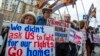 FILE - Protesters holding anti-American signs are seen gathered in front of the U.S. Embassy at a rally against what they see as American mingling in Russia's internal affairs, in Moscow, Russia, March 7, 2015.