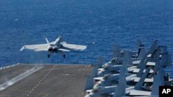 In this May 3, 2019, photo released by the U.S. Navy, An F/A-18E Super Hornet from VFA 25 launches from the flight deck of the Nimitz-class aircraft carrier USS Abraham Lincoln.