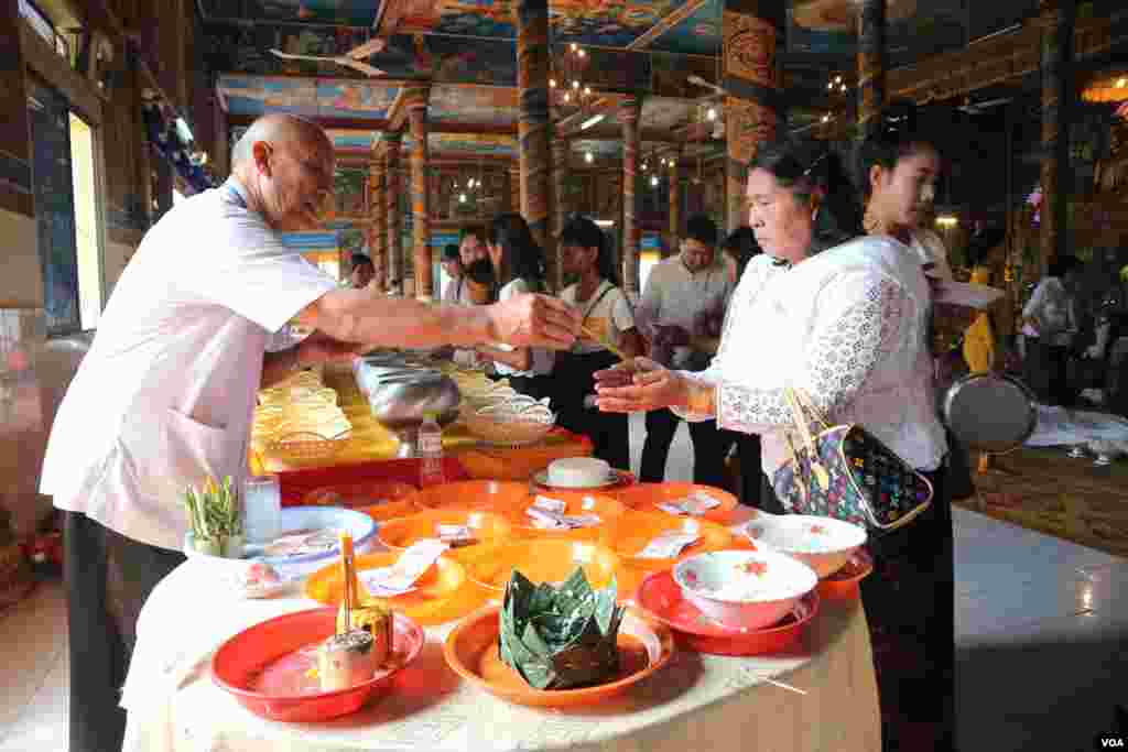 ប្រជាពលរដ្ឋម្នាក់ទទួលទឹកមន្តពីតាអាចារ្យ នៅក្នុងថ្ងៃកាន់បិណ្ឌទី១៣ នៃពិធីបុណ្យភ្ជុំបិណ្ឌនៅរាជធានីភ្នំពេញ នៅថ្ងៃទី២៦ ខែកញ្ញា ឆ្នាំ២០១៩។ (កាន់ វិច្ឆិកា/VOA)