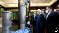 FILE - In this April 10, 2021, photo released by the official website of the office of the Iranian presidency, Iranian President Hassan Rouhani, second from right, listens to the head of the Atomic Energy Organization of Iran Ali Akbar Salehi.