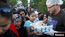 Des migrants syriens font la queue lors de la distribution de la nourriture près d'une route non loin d’Edirne en Turquie, 17 septembre 2015.