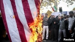 Un grupo de iraníes quema una bandera estadounidense en el aniversario del asalto a la Embajada de Estados Unidos en Teherán, Irán. 4 noviembre 2018. Tasnim News Agency / entrega vía Reuters.