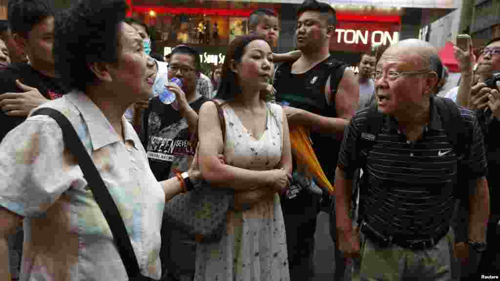 A pro-democracy protester, right, argues with an anti-Occupy resident, left, on Nathan Road blocked by pro-democracy protesters at Mongkok shopping district in Hong Kong, Oct. 20, 2014.
