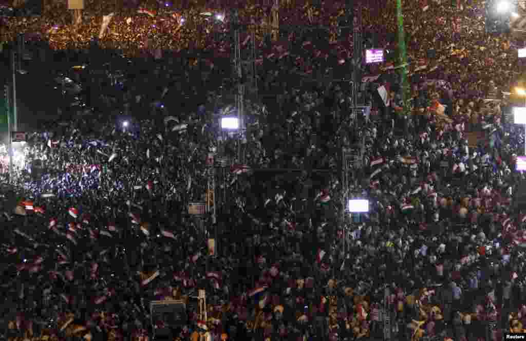 Protesters opposing Egyptian President Mohamed Morsi shout slogans and flash laser lights during a demonstration in front of the presidential palace in Cairo, July 2, 2013.
