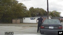 In this April 4, 2015, frame from dashboard video provided by the North Charleston Police Department, Patrolman Michael Thomas Slager stands by Walter Lamer Scott's car during a traffic stop in North Charleston, S.C. 