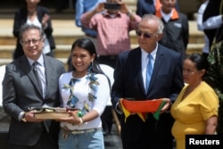 El ministro de Defensa de Colombia, Iván Velásquez (d), y el presidente Gustavo Petro posan para una foto junto a mujeres que ayudaron en el rescate de los niños sobrevivientes de un avión que se estrelló en la espesa selva de Colombia, el 26 de junio de 2023. REUTERS/Vannessa Jiménez