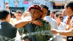 Un officier de police tunisien fraternise avec un soldat des vagues de manifestations appelées printemps arabe à Tunis, 8 septembre 2011. 