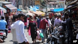 Indians wearing a mask as a precaution against the coronavirus shop at a market in Jammu, India, July 5, 2020. 