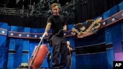 Un assistant de plateau passe l'aspirateur sur le plateau où va se dérouler mercredi 19 octobre le dernier débat entre Donald Trump et Hillary Clinton, à l'Université du Nevada, Las Vegas.