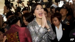 Thailand's former Prime Minister Yingluck Shinawatra, center, leaves parliament in Bangkok, Jan. 22, 2015.