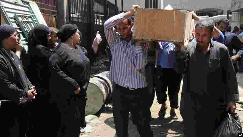 Egyptians remove a body for burial from the Zenhoum morgue in Cairo, August 19, 2013.