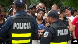 Migrantes cubanos participan en una protesta que bloquea la carretera Panamericana, exigiendo acceso a Nicaragua, en Peñas Blancas, Costa Rica, el martes 17 de noviembre de 2015.