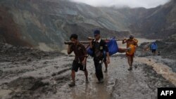 ကချင်ပြည်နယ် ဖားကန့်မြို့က မြေစာပုံပြိုကျမှုမှာ သေဆုံးသူများကို ကူညီသယ်ဆောင်ပေးနေတဲ့ မြင်ကွင်း။ (ဇူလိုင် ၀၂၊ ၂၀၂၀)