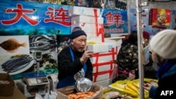 北京一家海鮮市場的小販正在向顧客兜售水產品。（2020年1月15日）