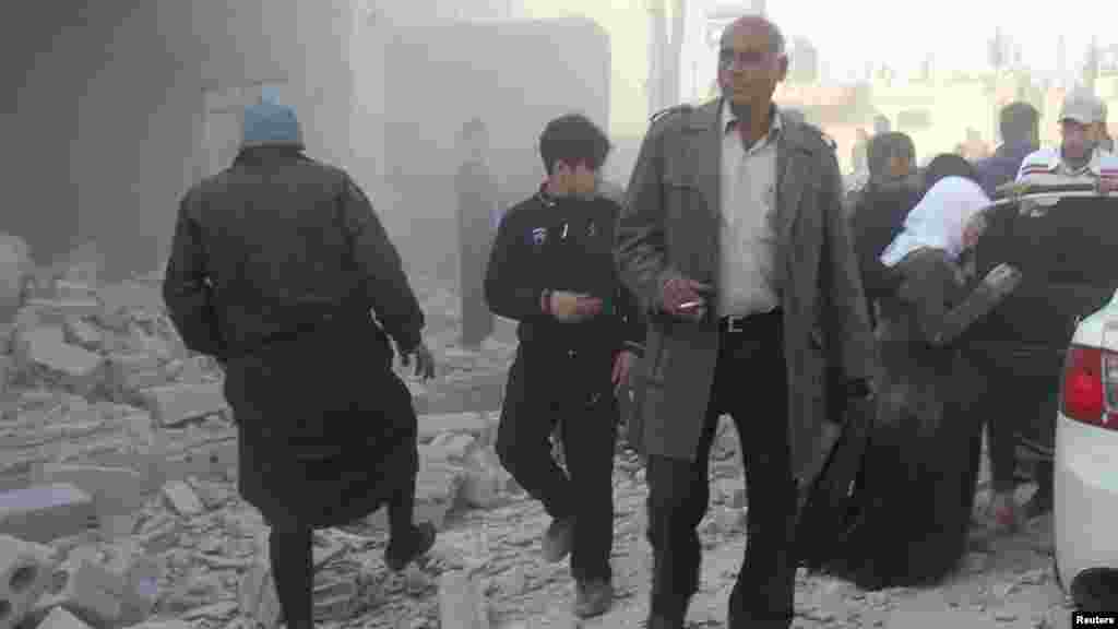 Residents inspect damage after what activists said was shelling from forces loyal to President Bashar al-Assad in Al-Atareb, Aleppo countryside, Syria, Feb. 16, 2014. 